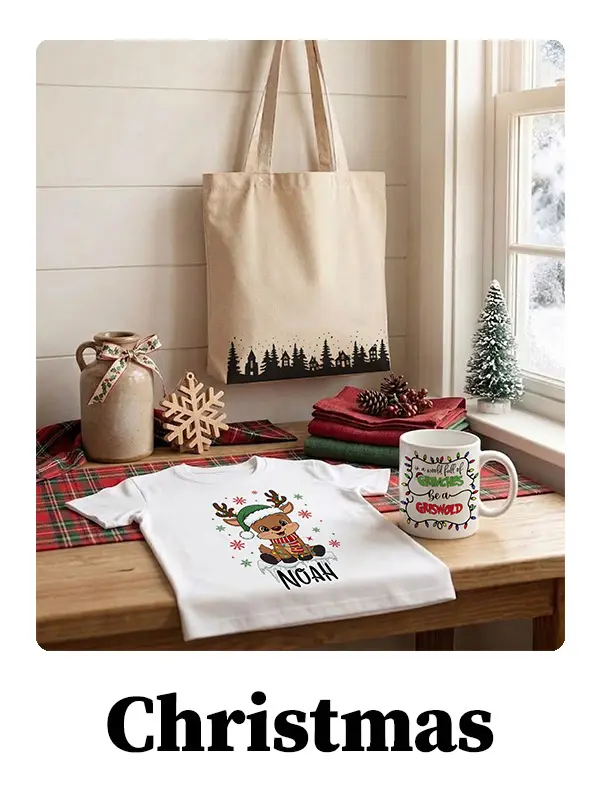 Christmas themed product display with custom name reindeer shirt, festive mug, and tote bag on cozy holiday table